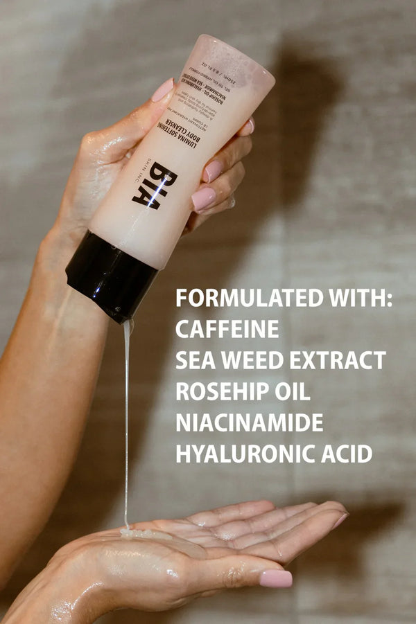 Hand holding Lumina Softening Body Cleanser with gel-to-oil formula pouring into palm, highlighting caffeine, seaweed extract, rosehip oil, niacinamide, and hyaluronic acid ingredients.